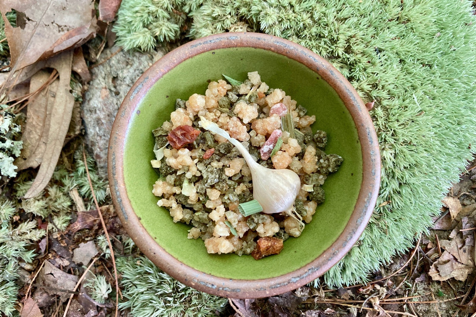 A grinder jar of Wild Ramp and Roasted Garlic Sea Salt from Well Seasoned Table on a wooden background